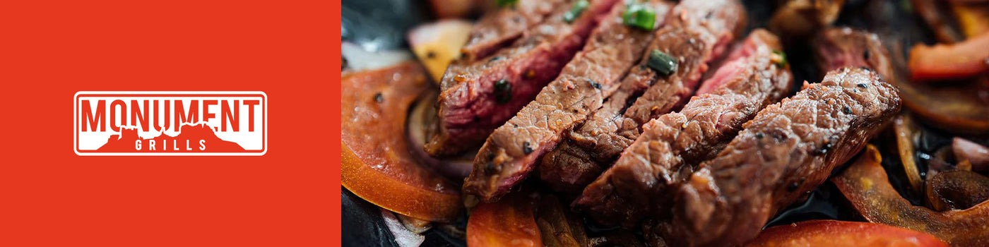 Steak dish with vegetables on a plate against an orange background with 'Monument Grills' logo.