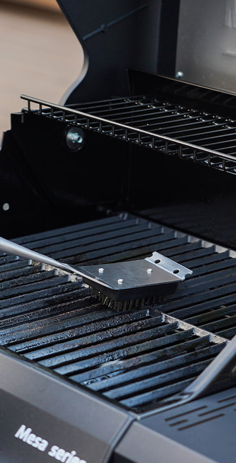 Close-up of a grill with a metal brush on it