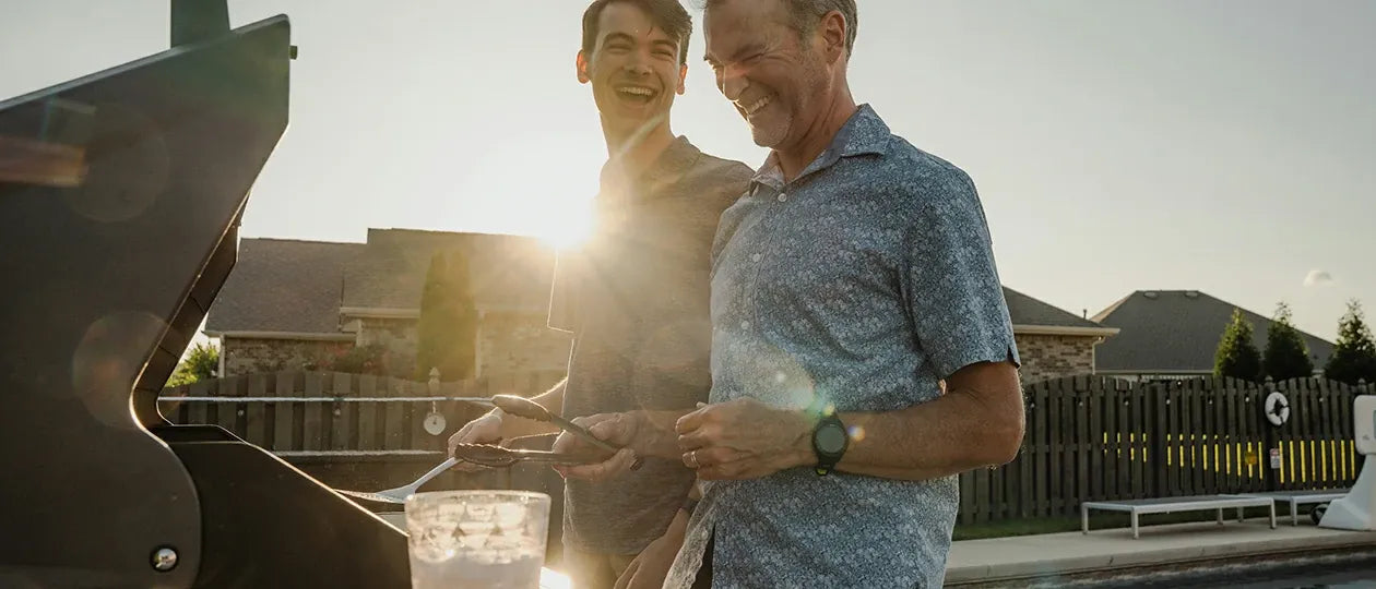 Father and son grill together