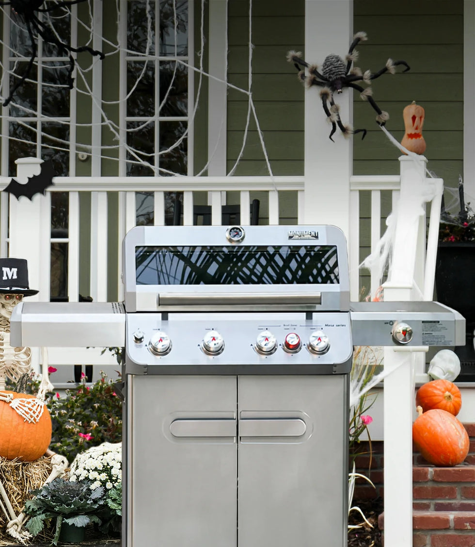 Outdoor grill on a porch decorated for Halloween with pumpkins and spider webs.