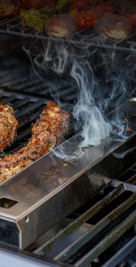 Smoking meat on a grill with a smoking device