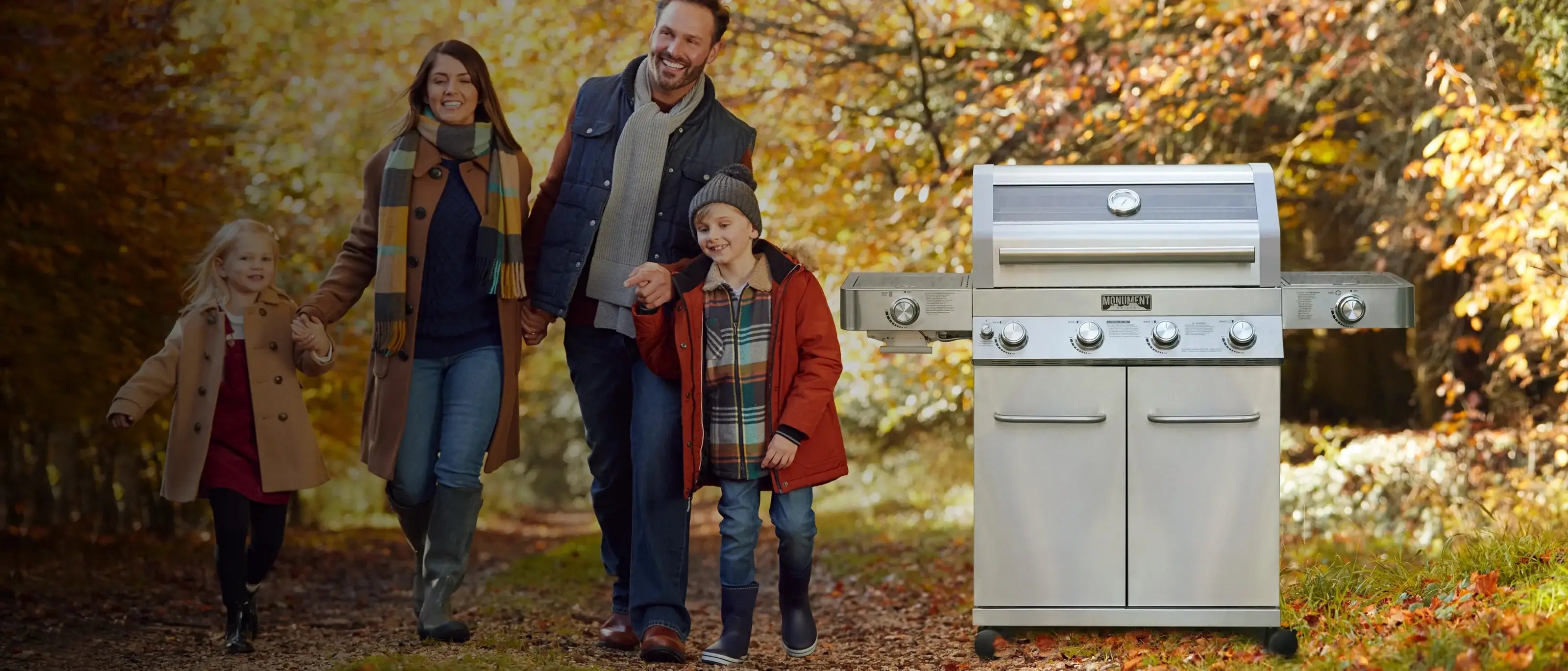 Family walking outdoors with a barbecue grill in the foreground