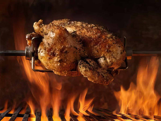 Roasted chicken on a rotisserie over flames