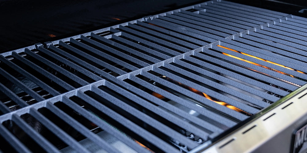 Close-up of a grill grate with visible flames, brand 'AVC' on the side.