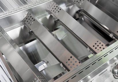 Stainless steel interior of a kitchen appliance with shelves and compartments.