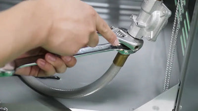 Person using a wrench on a mechanical component with a blurred background