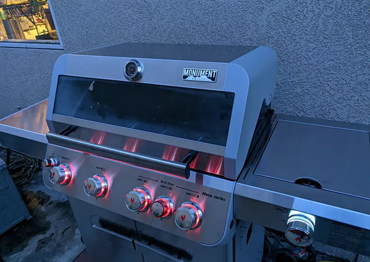 Hamilton Beach grill with glowing burners on a patio background