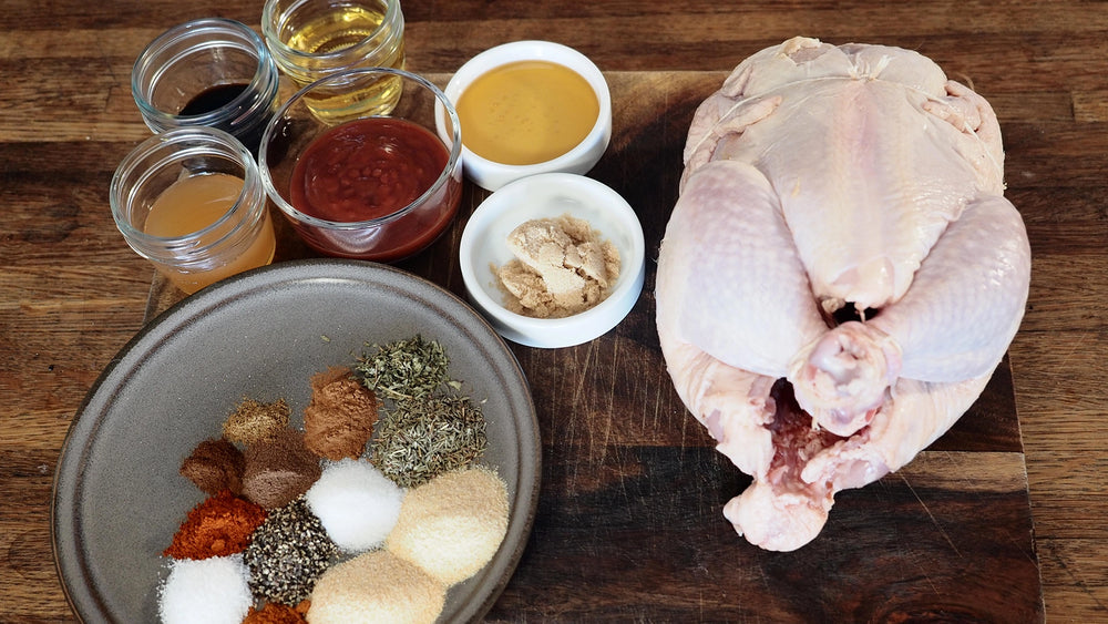 Raw chicken with spices and seasonings on a wooden surface