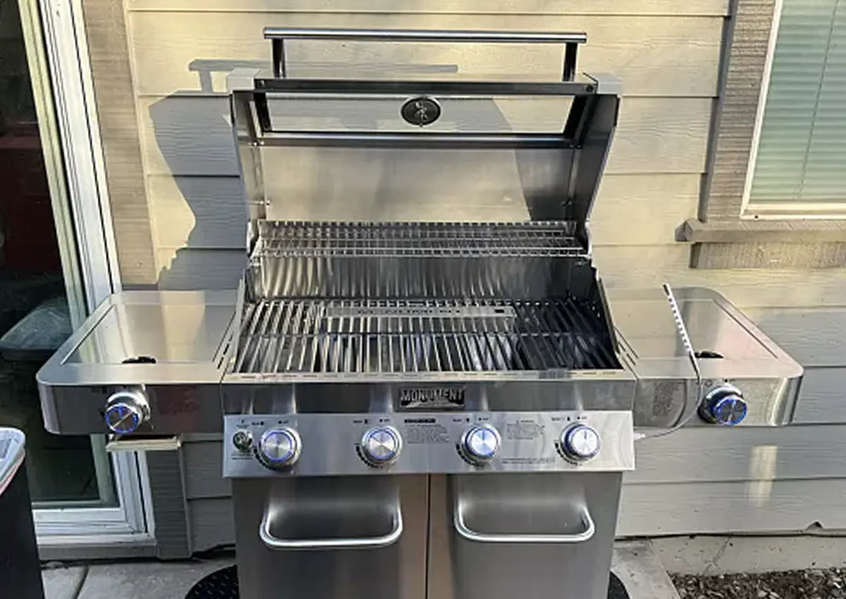 Stainless steel grill with multiple burners on a patio