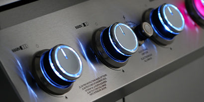 Close-up of control knobs on a piece of electronic equipment with blue and pink lighting.