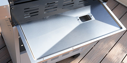 Open grill lid on a wooden surface