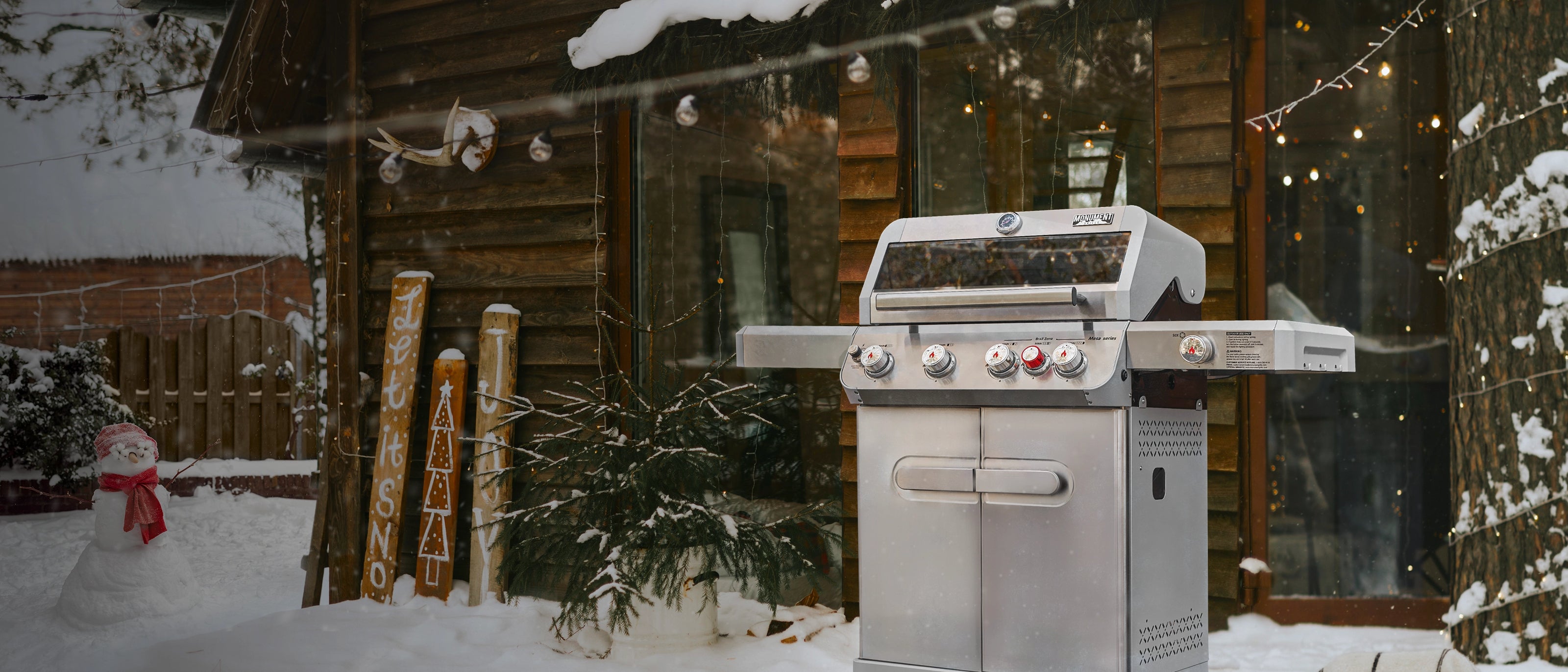 Outdoor grill in front of a wooden cabin with snow on the ground