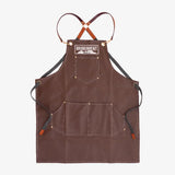 Brown apron with black straps on a white background, featuring 'Monument' branding.