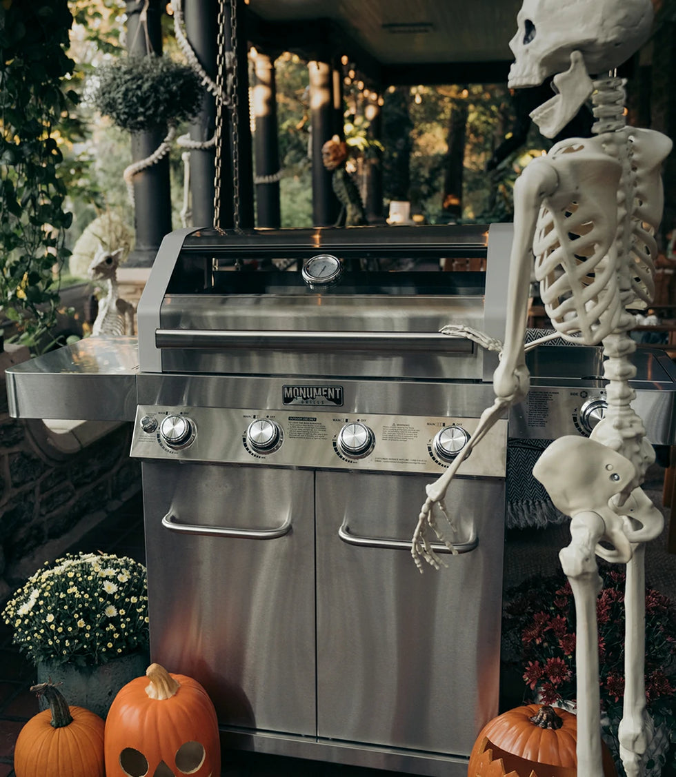 Stainless steel grill with a skeleton and pumpkins in a Halloween-themed setting